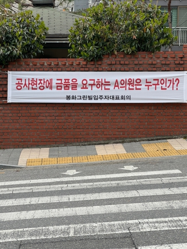 순천시 조례동 봉화그린빌 아파트 입구에 금품수수 의혹을 받고 있는 순천시의원을 질타하는 현수막이 부착돼 있다.