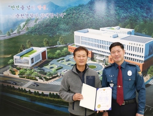 국승인 순천경찰서장(오른쪽)이 3일 실종 노인을 찾아 준 순천 동신교통 버스 운전원 신모씨에게 감사장을 전달한 뒤 주인공이 빛나도록 가운데로 모신 뒤 자신은 한쪽으로 비켜 기념 촬영하고 있다.